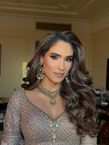 A close-up of this stunning Roka makeup. The bold smokey eye and perfectly sculpted brows are paired with voluminous curls for a glamorous start to the wedding festivities.