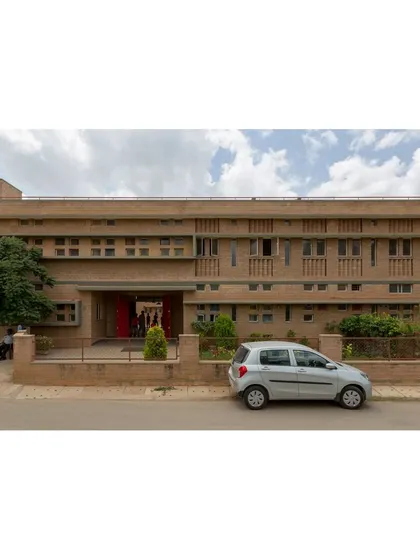 The main entrance of Buddhi School, showcasing the warm texture of compressed stabilised earth block (CSEB) masonry. The entire school is designed to be fully accessible and was built on existing rock to minimize foundation costs and preserve the natural landscape.