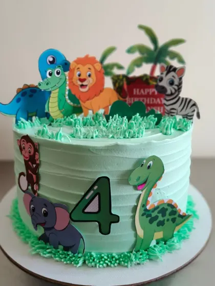This jungle themed cake is ready for a fourth birthday adventure, featuring a mix of friendly dinosaurs and safari animals.