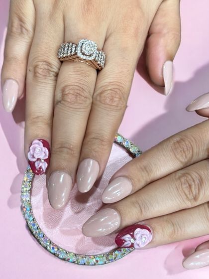 An elegant nude almond set with two accent nails featuring hand-painted 3D roses.