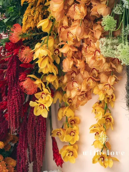 A close-up of cascading yellow orchids, part of the vibrant floral design for the 'Garden of Gaia' baby shower.