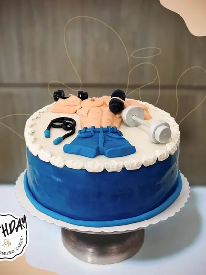 A cake that's fit for a fitness enthusiast. This gym-themed cake features fondant dumbbells, a skipping rope, and workout clothes, perfect for a gym freak's birthday.