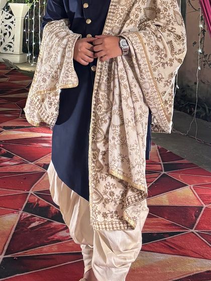 A closer look at the details of our navy blue Indo-Western outfit. The embroidered shawl adds a touch of luxury to this modern rental piece.