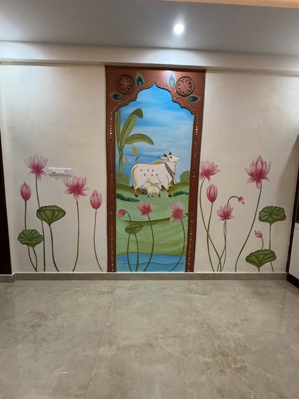 A full view of a unique Pichwai-inspired wall combining painting, lippan art with ropes, and textured concrete. The central scene is framed like a traditional window, with lotuses blooming on either side.