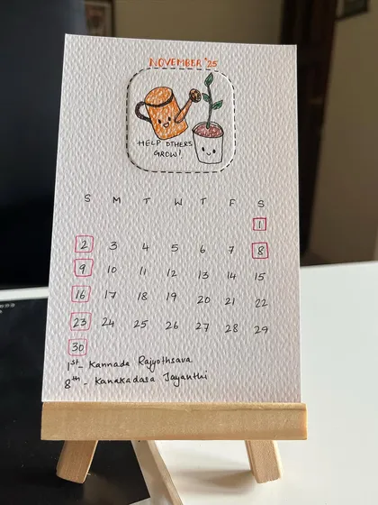 Here’s a close-up of my 2025 hand-drawn desk calendar. Each month features a unique, punny doodle on eco-friendly, recycled paper, and it comes with this cute little wooden easel to sit perfectly on your desk.