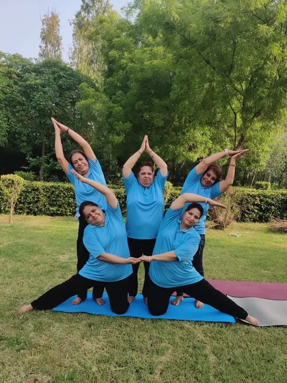 A beautiful group pose celebrating International Yoga Day, where students connect to create a star shape, symbolizing unity and shared energy.