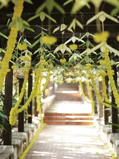 This outdoor walkway at Chairman's Jade resort was decorated for a wedding. I hung garlands of yellow flowers and traditional woven leaf elements from the wooden pergola to create a beautiful path for guests.