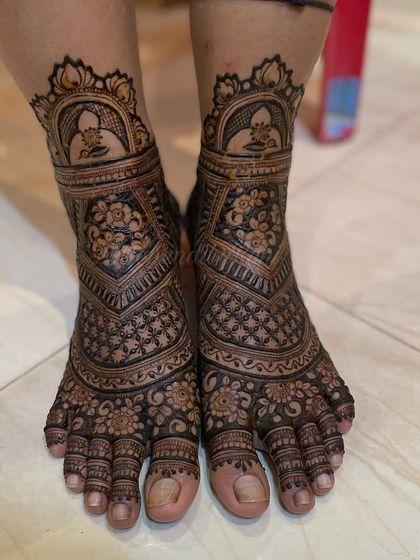 A step-by-step look at a bridal foot design. This image shows the completed work, with a figure inside a dome, surrounded by intricate floral and geometric patterns.