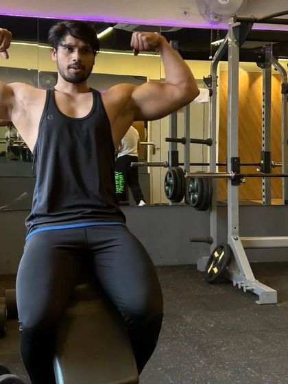 A closer shot of the seated double bicep pose.