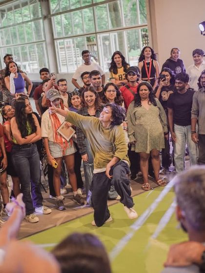 A dancer commands the circle during the 1v1 Hip-Hop battle, with the crowd fully engaged in the moment.