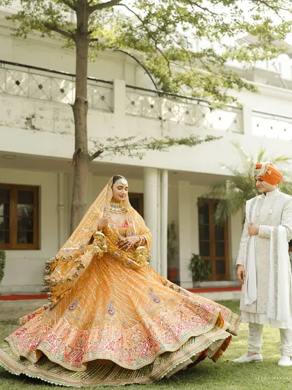 A playful twirl to showcase a stunning lehenga. The bride's orange Rimple and Harpreet creation is full of life and color, a perfect representation of her vibrant personality, styled for her Anand Karaj ceremony.