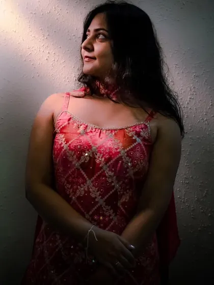 A similar artistic portrait where the bride is looking towards a sliver of light. This technique, known as Rembrandt lighting, adds a classic and painterly quality to the photograph.