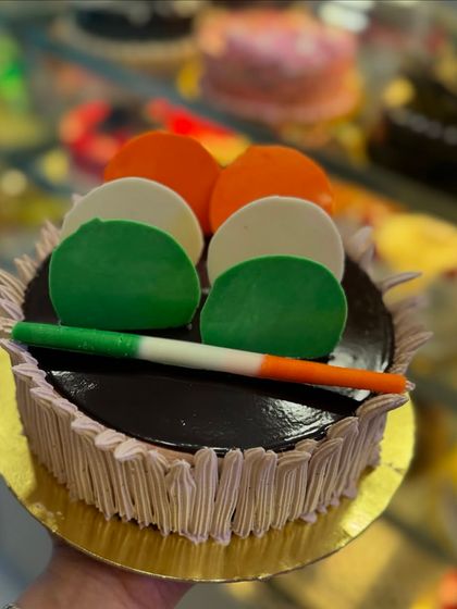 An Independence Day special chocolate cake decorated with tricolor chocolate discs and a roll. It's a delicious way to show patriotic spirit.