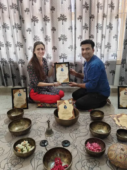 Presenting a certificate to a student, acknowledging her successful completion of the sound healing training.