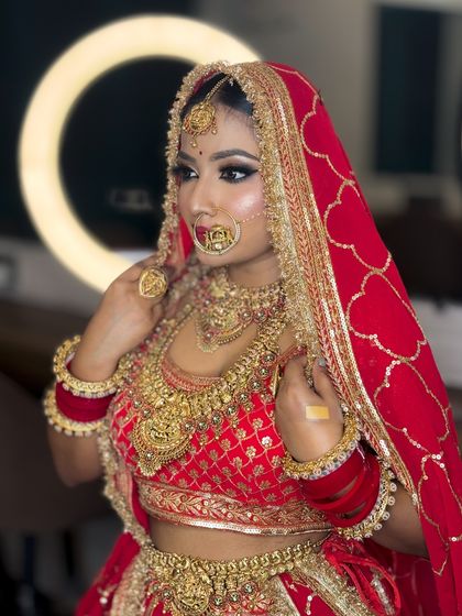 A beautiful shot of a bride with a ring light in the background, highlighting her glowing skin and the details of her red dupatta.