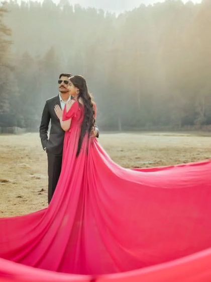 The wind catches the hot pink trail, creating a beautiful wave of color that frames the couple. This is a perfect gown for a shoot in an open, natural landscape.