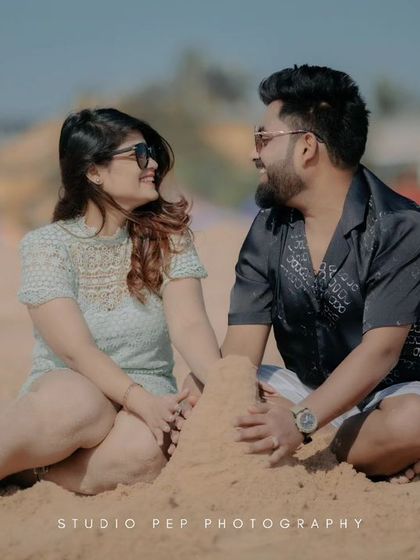 A sweet moment of them building a sandcastle together. This shot is a beautiful metaphor for building their future, captured with a genuine, happy smile.