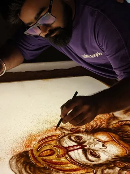 Working in my studio, bringing the powerful image of Hanuman ji to life with sand.
