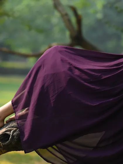An abstract and artistic shot focusing on the flow of the dress and the natural setting.