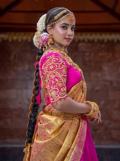 The complete bridal look from the side, showcasing the detailed embroidery on the blouse and the traditional long braid. I ensure every element, from the makeup to the hair, works together for a cohesive and beautiful result.
