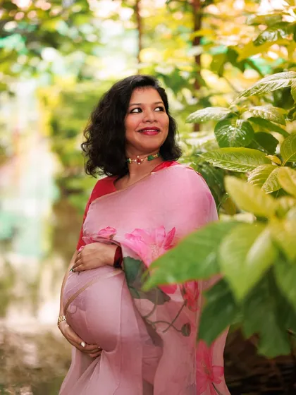 Surrounded by nature, this mama-to-be looks like a painting. The floral pink saree complements the lush greenery, creating a portrait of grace, strength, and new beginnings.