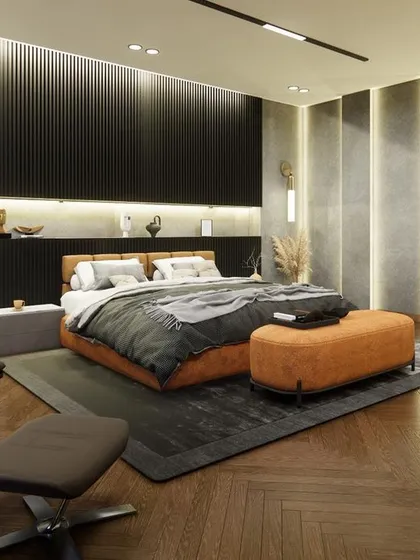 An angled view of the Noida bedroom, highlighting the comfortable lounge chair and the vertical grooves on the wall. This design choice adds height and texture, enhancing the room's modern and luxurious feel.