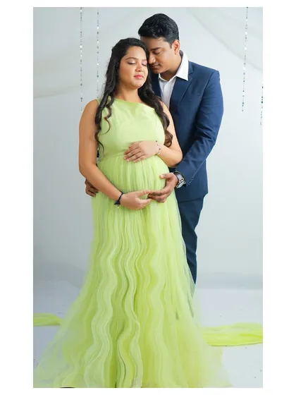 The quiet, tender moments between partners are so precious. In this shot, I captured the gentle connection between the couple, her in a vibrant lime-green gown, as they share a moment of anticipation for their baby's arrival.