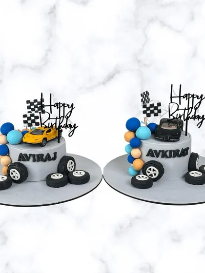 Another look at the custom race car cakes for Aviraj and Avkirat. These personalized cakes are perfect for celebrating birthdays together in style.