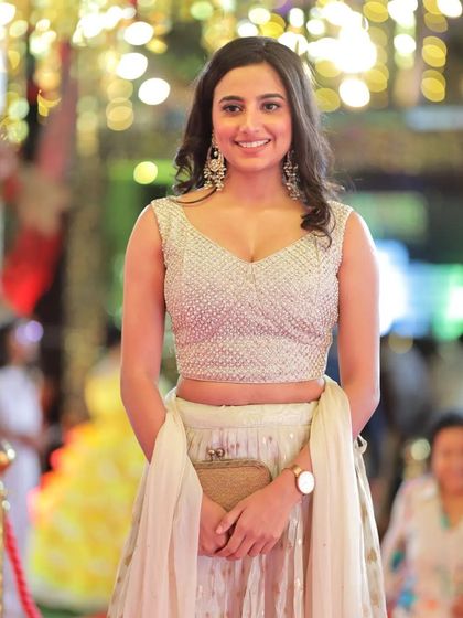 A candid shot of actress Shivani Rai smiling on the red carpet, showcasing her sparkling lehenga and the glamorous atmosphere of the event.