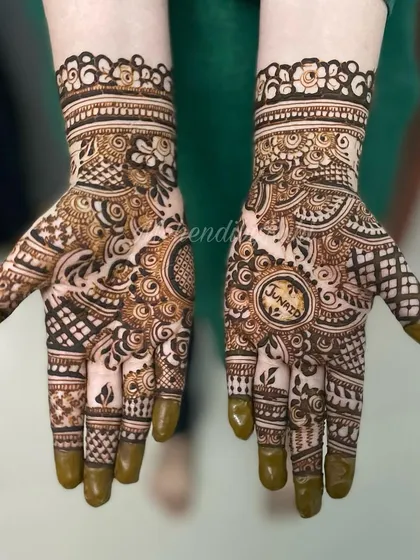Another example of personalization, this time with the name 'Junaid' placed inside a central circle on the palm. It becomes the heart of the entire mehendi design.