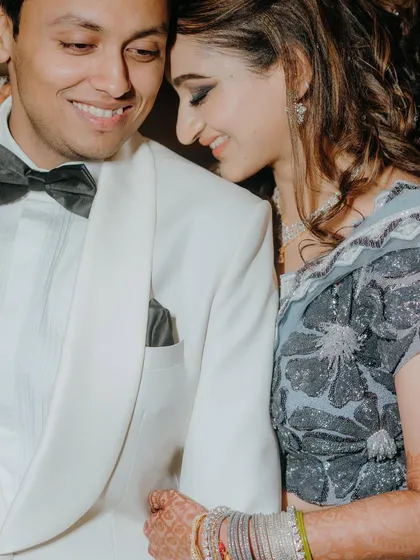 A close-up, candid moment filled with warmth and affection. This photo captures the genuine smiles and easy chemistry between the couple during their Sangeet, a quiet moment amidst the celebration.