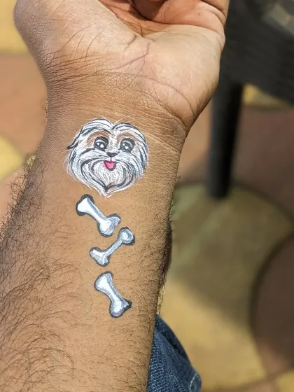 A shih tzu portrait with a trail of bones, a perfect tattoo for a dog lover.