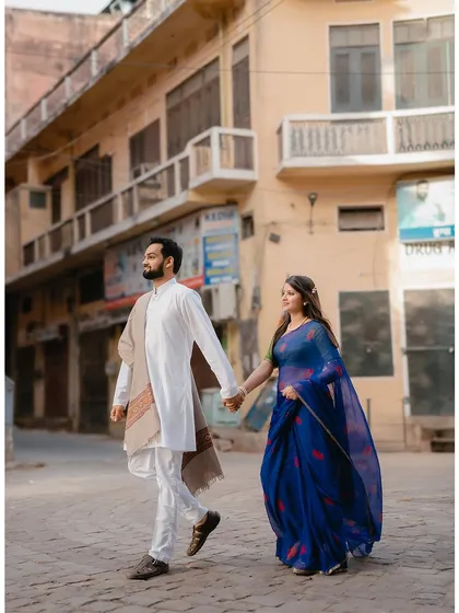 A stylish walking shot through the streets of Jaipur, capturing the city's unique architecture and the couple's effortless connection.