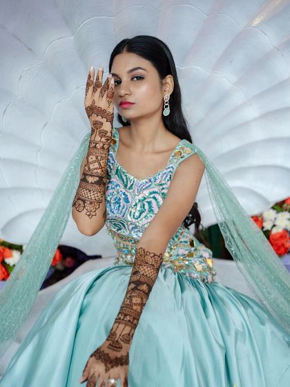 A mermaid-themed bride posing elegantly, showing off the unique design on her arms.