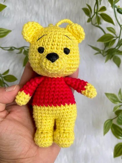 A sweet Winnie the Pooh keychain. This classic character is perfect as a small, adorable accessory to hang on a bag or keys, bringing a little bit of the Hundred Acre Wood with you.