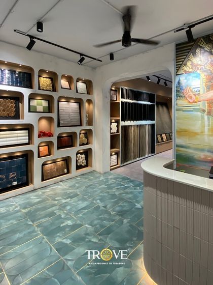 The reception area of my Whitefield experience center, where luxury meets variety. The space features a custom mural, a wall of unique tile samples in alcoves, and beautiful floor tiles, setting the stage for a creative and inspiring tile selection journey.