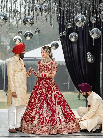 A beautiful shot of the couple. The bride's red lehenga and classic makeup look absolutely stunning against the modern decor.