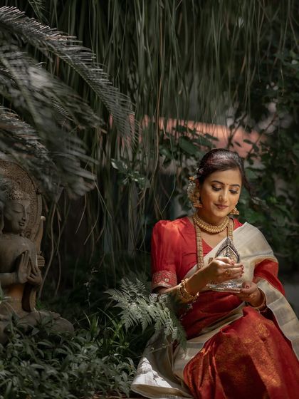Holding a traditional silver lamp, our model embodies the sanctity of the wedding ceremony. This Kanchipuram silk saree is designed for moments of reverence and celebration.