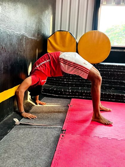 This student uses the wall to deepen his backbend stretch safely.