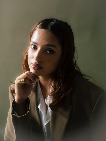 A soft, elegant portrait with a diffused, hazy effect. The olive green background and the model's gentle expression create a timeless and painterly quality, perfect for a sophisticated campaign.