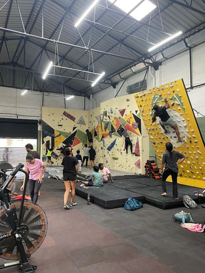 The gym is buzzing with energy during one of our Bangalore meetups. Climbers explore different routes on the bouldering wall while others rest and socialize on the mats.