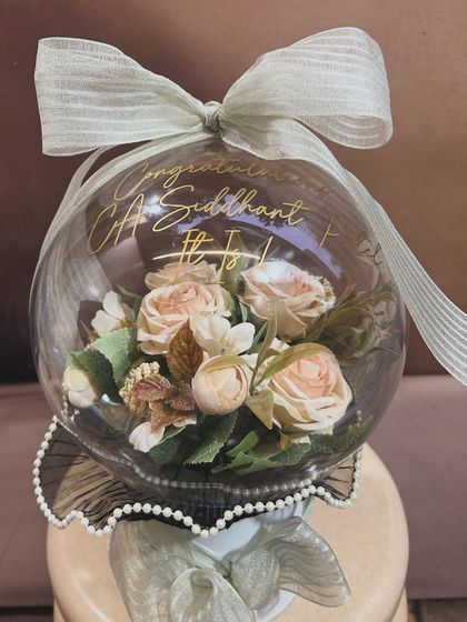 A unique way to say congratulations! This blooming acrylic bubble balloon was created to celebrate a new CA, Siddhant. The beautiful artificial flowers inside create a lasting and elegant keepsake.