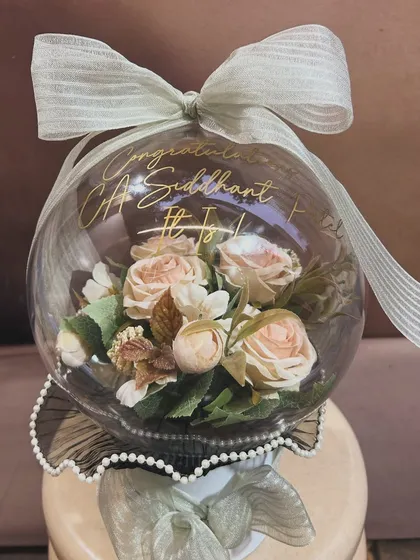 A unique way to say congratulations! This blooming acrylic bubble balloon was created to celebrate a new CA, Siddhant. The beautiful artificial flowers inside create a lasting and elegant keepsake.