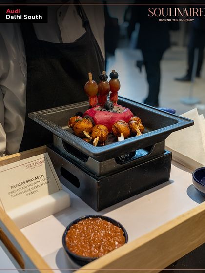An artistic presentation of Patatas Bravas at the Audi Delhi South Art Exhibition, featuring Salvador Dalí's work. Our menus are creatively designed to complement the theme of any exclusive event.