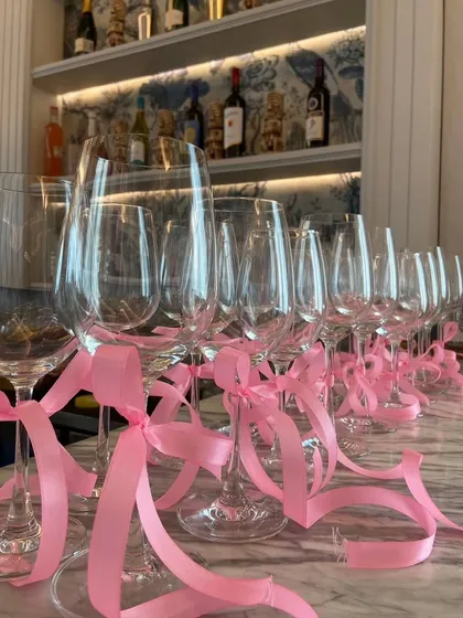 I added simple pink ribbons to the wine glasses at the bar. This small touch helps carry the theme throughout the entire venue and adds a pop of color.