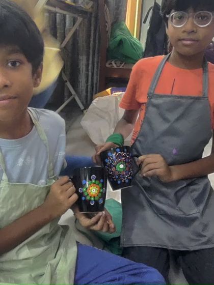 The birthday boys, Kushagra and Geetarth, showing off the intricate dot mandala mugs they painted.