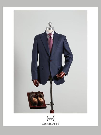 This single-breasted navy suit is a cornerstone of any professional wardrobe. Its versatility and timeless appeal are enhanced by our bespoke fit and quality fabric.