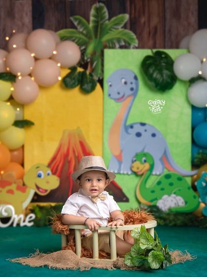 A little explorer in a dinosaur park, ready for a prehistoric adventure. The colorful backdrop and props make the theme come alive.