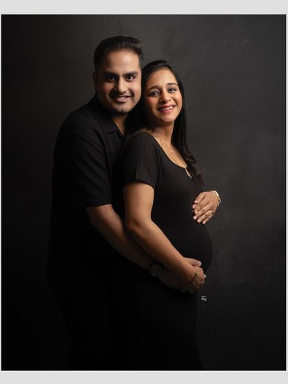 A classic couple's portrait for expecting parents. The way they hold each other and smile at the camera creates a warm and lasting memory.