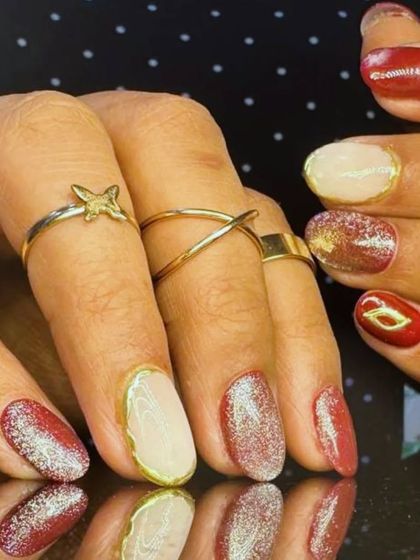 A side view of the multi-finish manicure, showing the combination of glitter, cream, and metallic-outlined nails.